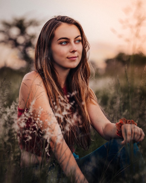 Una bella giovane donna sul campo contro il cielo