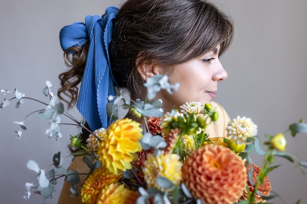 Una bella giovane donna tiene in mano un mazzo di crisantemi.