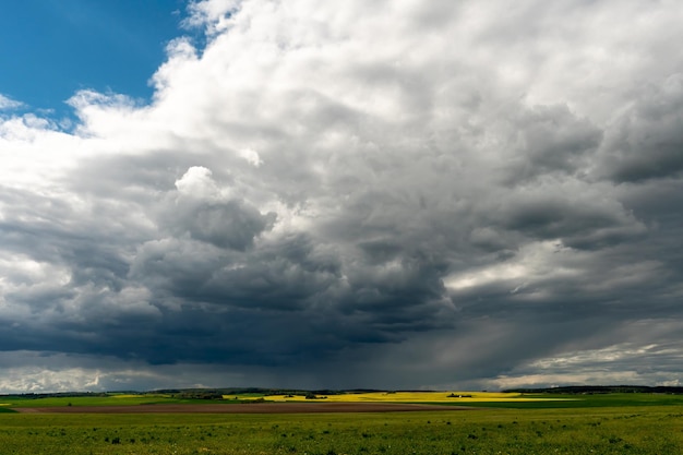 Una bella nuvola temporalesca con pioggia aleggiava su un campo di grano Una terribile nuvola nera alla vigilia di un tornado e di una calamità naturale Un uragano in campagna