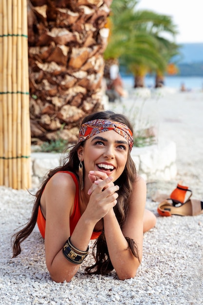 Una bella ragazza allegra giace sulla spiaggia e alza lo sguardo.