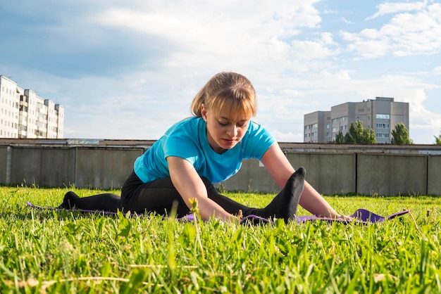 Una bella ragazza bionda si scalda e fa esercizi di ginnastica