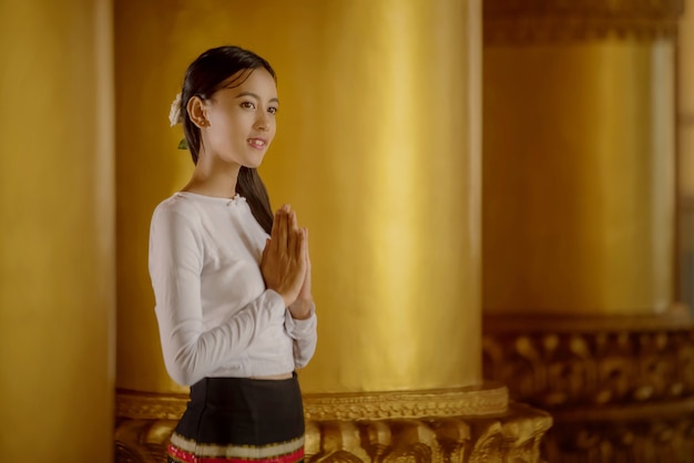 Una bella ragazza birmana che indossa un costume nazionale per una passeggiata, all'interno della Pagoda Shwedagon di Yangon, Myanmar.