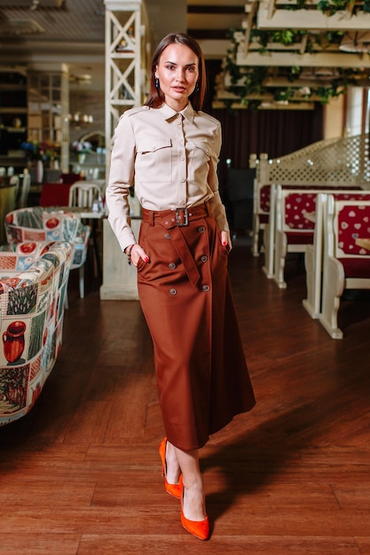Una bella ragazza che mostra abiti alla moda sullo sfondo del paesaggio del ristorante Abiti per lo showroom