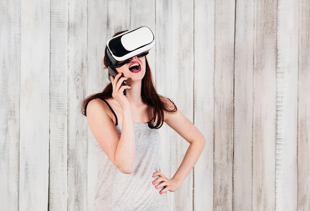 Una bella ragazza con gli occhiali VR, ridendo parlando al cellulare