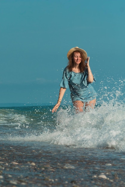 Una bella ragazza d'estate in riva al mare che si diverte felicemente sull'acqua con le emozioni