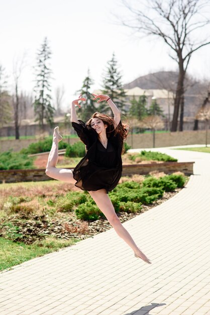 Una bella ragazza è impegnata nella coreografia in natura.