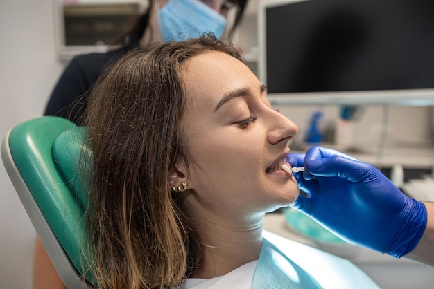 Una bella ragazza è venuta dal dentista per un sbiancamento professionale dei denti.
