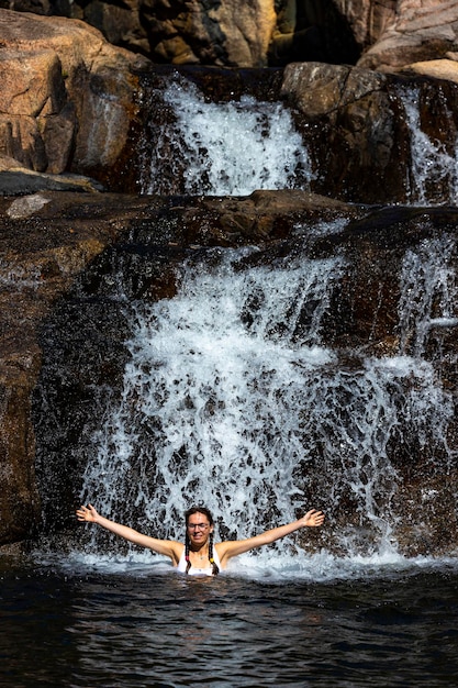 una bella ragazza in bikini bianco nuota in una piscina naturale a jourama falls, queensland, australia