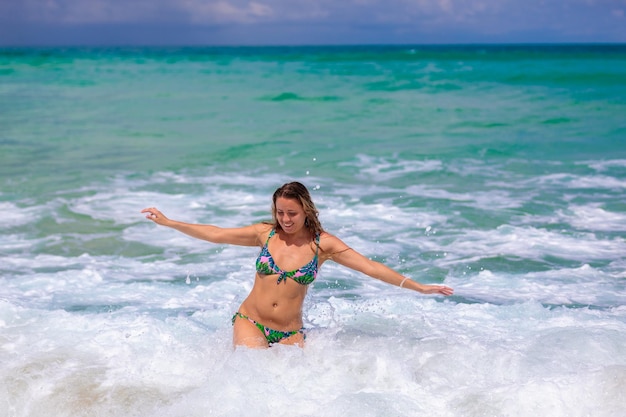 Una bella ragazza salta in mare con felicità si rallegrò nelle onde