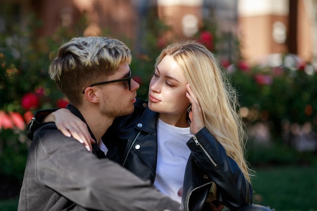 Una bella ragazza seduta sulle ginocchia del suo ragazzo e guardando il suo viso