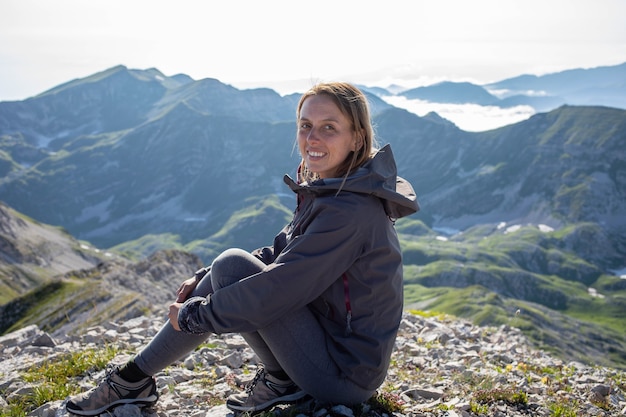 Una bella ragazza sorridente in cima alle montagne