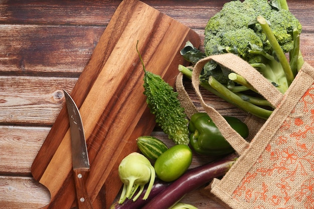 Una bella varietà di verdure fresche esposte su un tavolo di legno rustico con una borsa