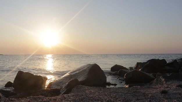 Una bellissima alba sul mare sfondi di pietra in primo piano