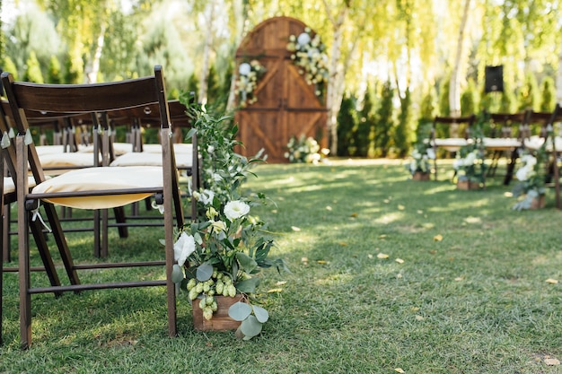 Una bellissima area per una cerimonia di matrimonio all'aperto Arco Decorato con un grande portone in legno con tanti fiori