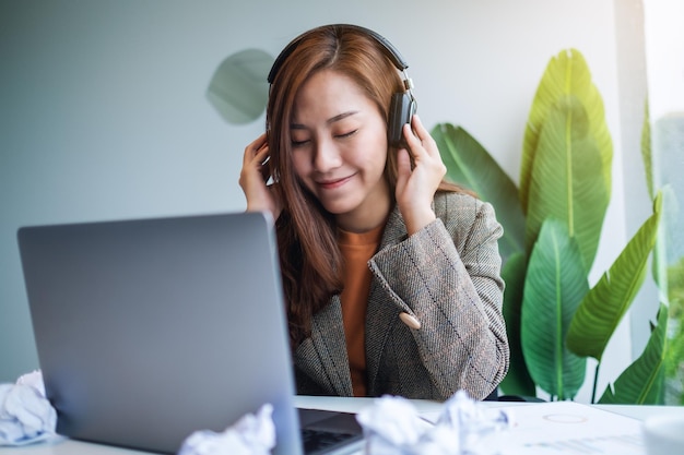 Una bellissima giovane donna d'affari si diverte ad ascoltare musica per alleviare lo stress sul lavoro