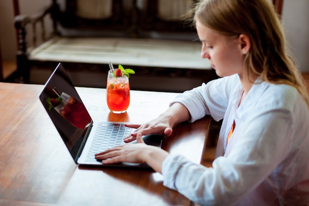 Una bellissima giovane donna lavora sul suo laptop