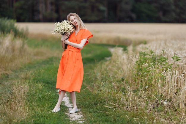 Una bellissima giovane donna sta camminando in un campo di grano