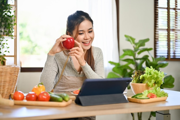 Una bellissima influencer culinaria asiatica in diretta streaming sui suoi social media mentre cucina