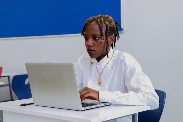 una bellissima studentessa nera che studia usando un computer portatile