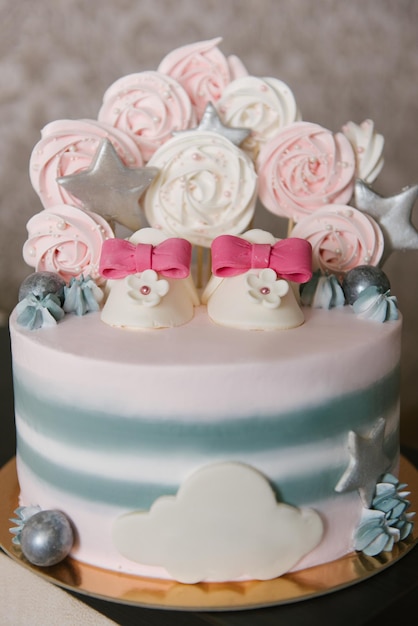 Una bellissima torta a base di ingredienti naturali con scarpe per bambini nei colori rosa e grigio per il compleanno o il battesimo di una ragazza