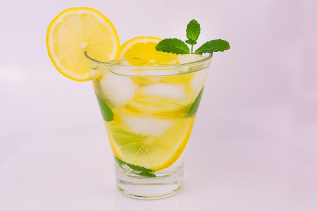 Una bevanda rinfrescante a base di limoni alla menta e cubetti di ghiaccio su sfondo bianco