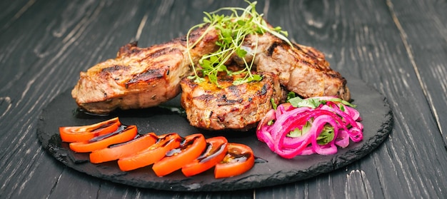 Una bistecca di manzo con spezie e verdure su un tavolo di legno