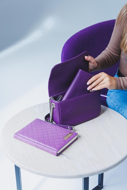 Una borsa in pelle viola in mano a una ragazza Donna con borsa di lusso