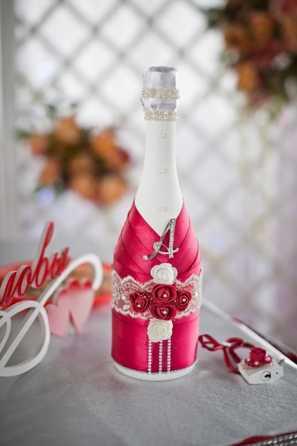 Una bottiglia di champagne decorata con nastri rossi 2812