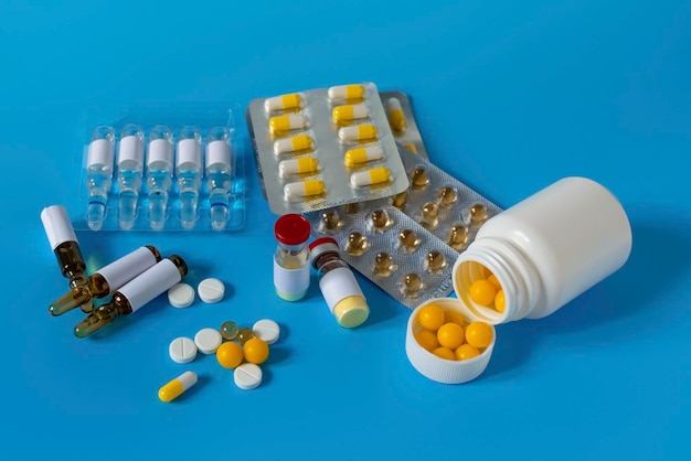 Una bottiglia di medicinale accanto a una siringa Medicinali per il virus e l'influenza pillole antibiotici Dispositivi di protezione individuale per il coronavirus maschera medica monouso farmaci con una siringa vaccino e pillole