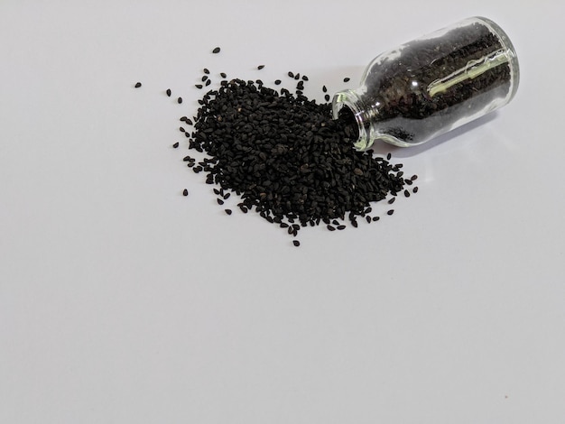 Una bottiglia di semi neri su sfondo isolato