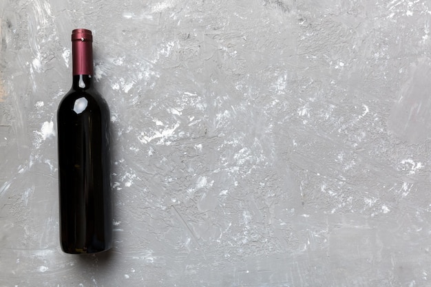 Una bottiglia di vino rosso su tavolo colorato Vista dall'alto piatto con spazio per la copia