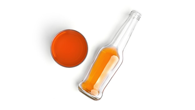 Una bottiglia e un bicchiere con aranciata su uno sfondo bianco