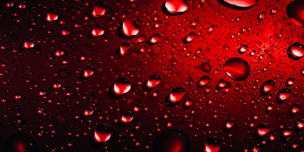 Una bottiglia rossa con gocce d'acqua su di essa