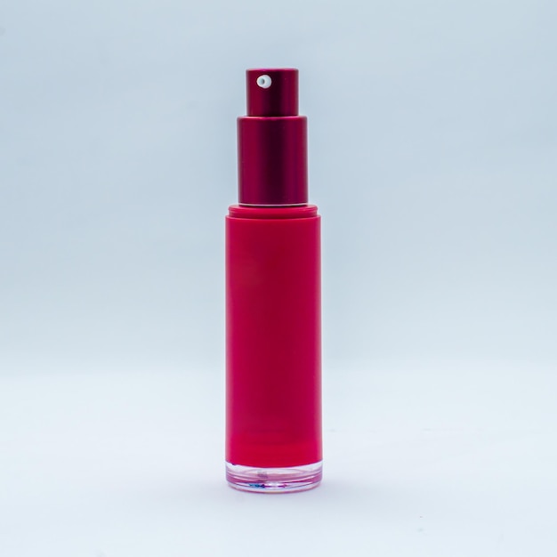 Una bottiglia rossa di profumo con un tappo rosso in cima.