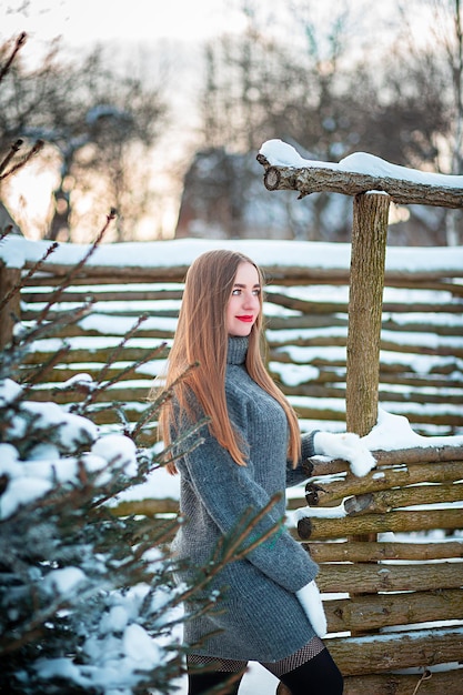 Una cabina invernale come in una fiaba nel parco Ragazza che cammina nella neve con un vestito Lunghi capelli biondi