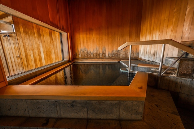 Una camera in legno con vasca idromassaggio e parete in vetro