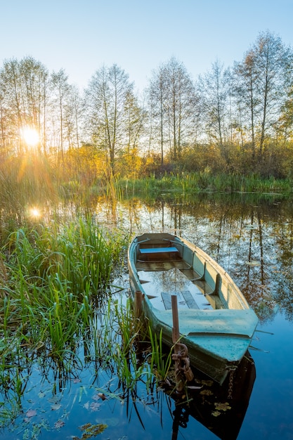 Una canna da pescatore sullo sfondo di un tramonto del fiume