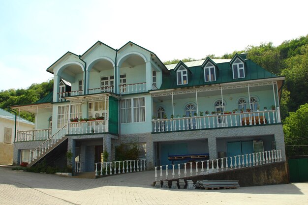 una casa con un tetto verde e un balcone bianco con un tetto verde