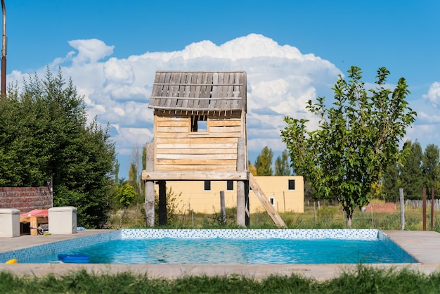 Una casa di legno con una piscina davanti