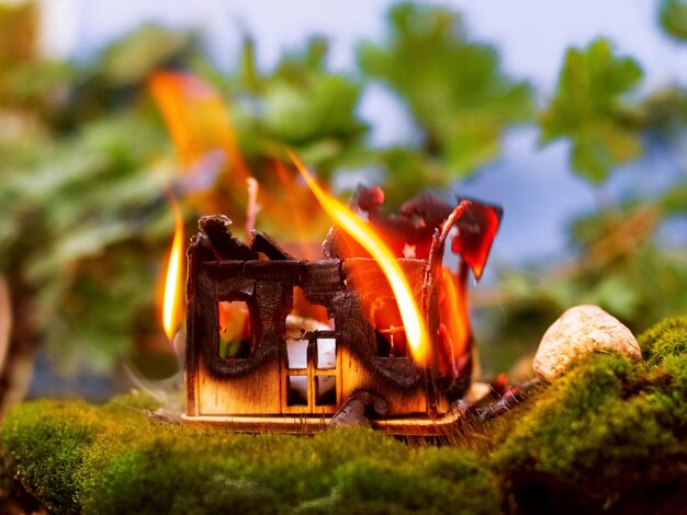 Una casa di legno giocattolo sta bruciando in natura Concetto antincendio Sicurezza antincendio