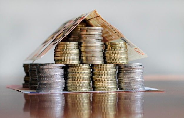 Una casa fatta di monete e banconote in euro - investimento in affitto ipotecario