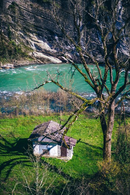 Una casa su una collina con un fiume sullo sfondo