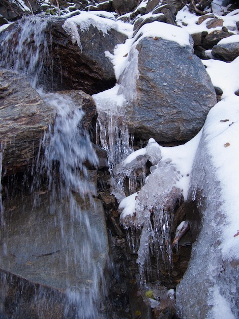 Una cascata nella neve con la neve sulle rocce