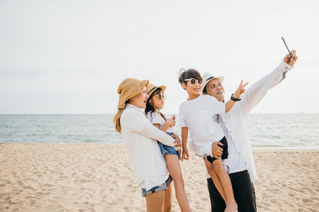 Una celebrazione sul lungomare dei legami familiari mentre si fanno un vivace selfie vicino al mare Le risate e la gioia abbondano creando un cordiale ritratto di solidarietà durante la loro escapada estiva