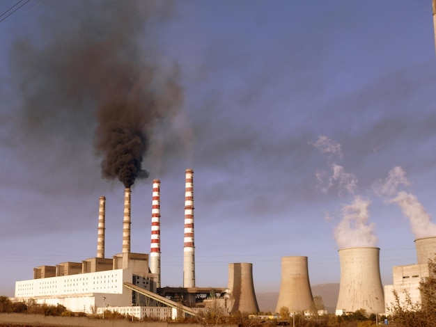 Una centrale elettrica alimentata a carbone con il fumo che fuoriesce dai camini.