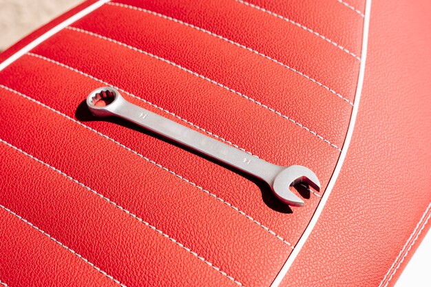 Una chiave sul sedile in pelle di una motocicletta durante la riparazione