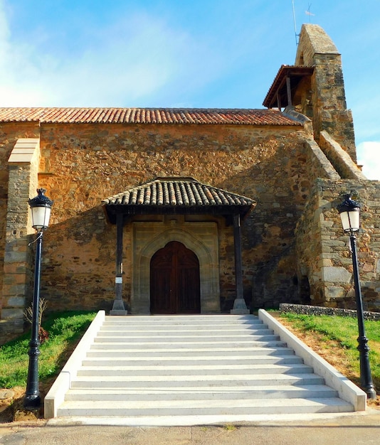 Una chiesa con un ingresso in pietra e un edificio in pietra con un tetto che dice "la casa".