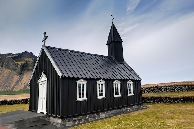 Una chiesa nera con tetto bianco e tetto nero.