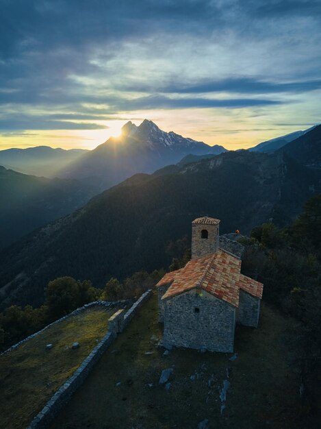 Una chiesa su una collina con le montagne sullo sfondo