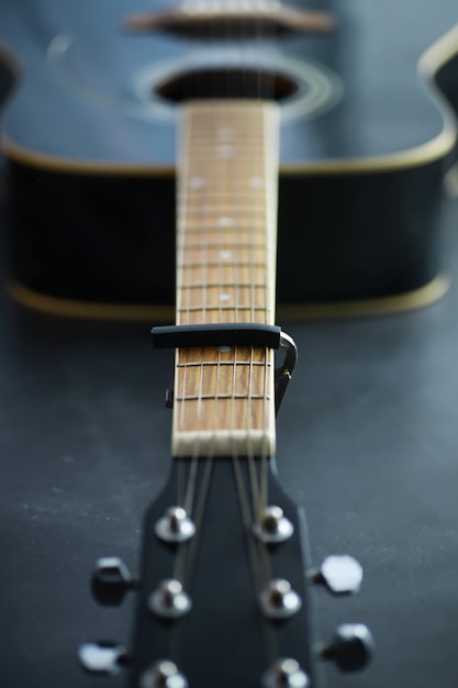 Una chitarra acustica per un artista che suona uno strumento musicale a corde sul palco. Chitarra nera con capotasto. Sottofondo musicale.